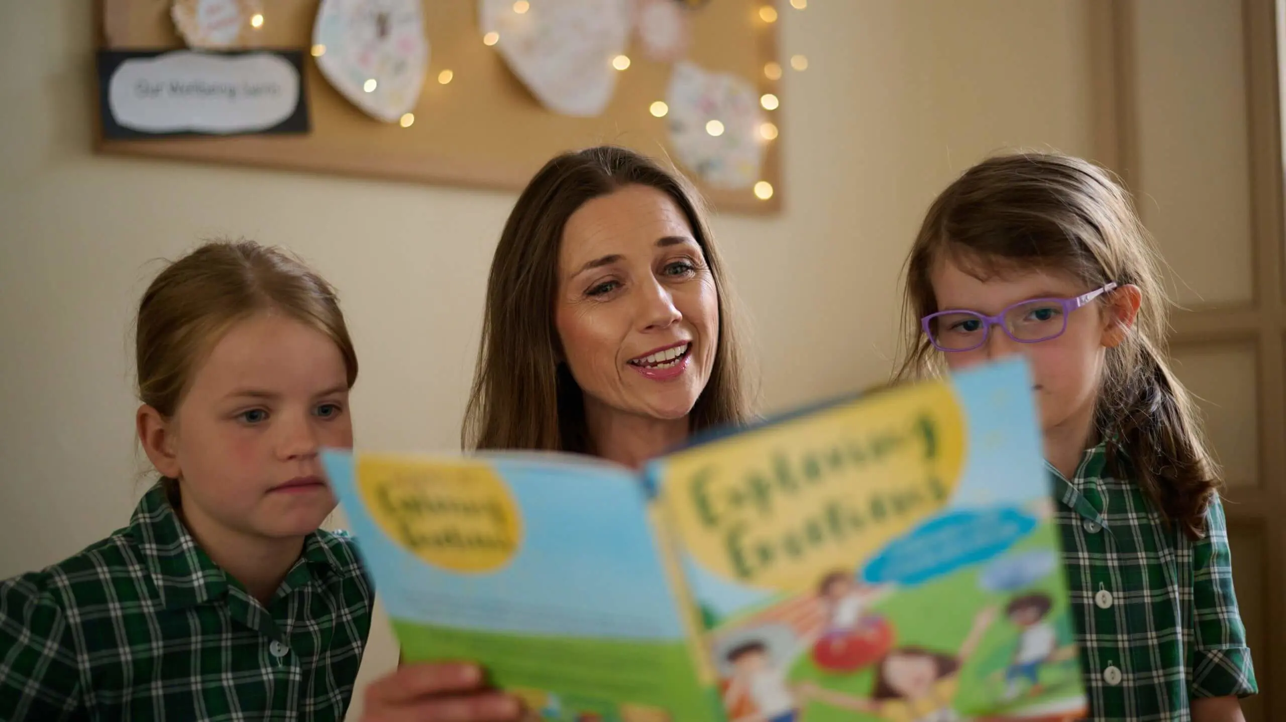 Teacher reading book with young students