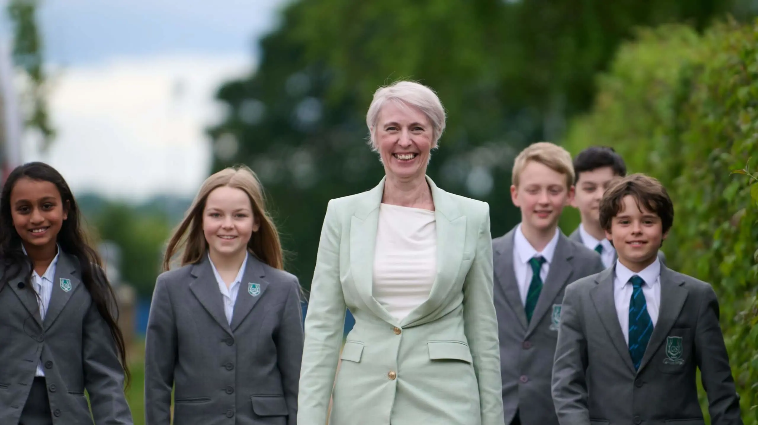 Head of The Grange School walking outside with Year 7 pupils.