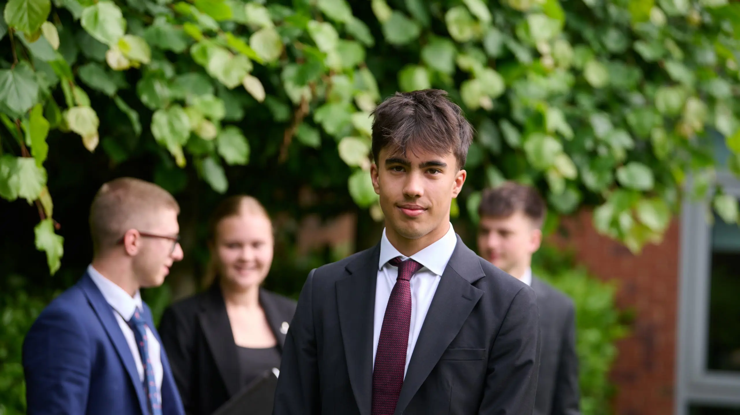 The Grange School Sixth Form Pupils outside under tree.