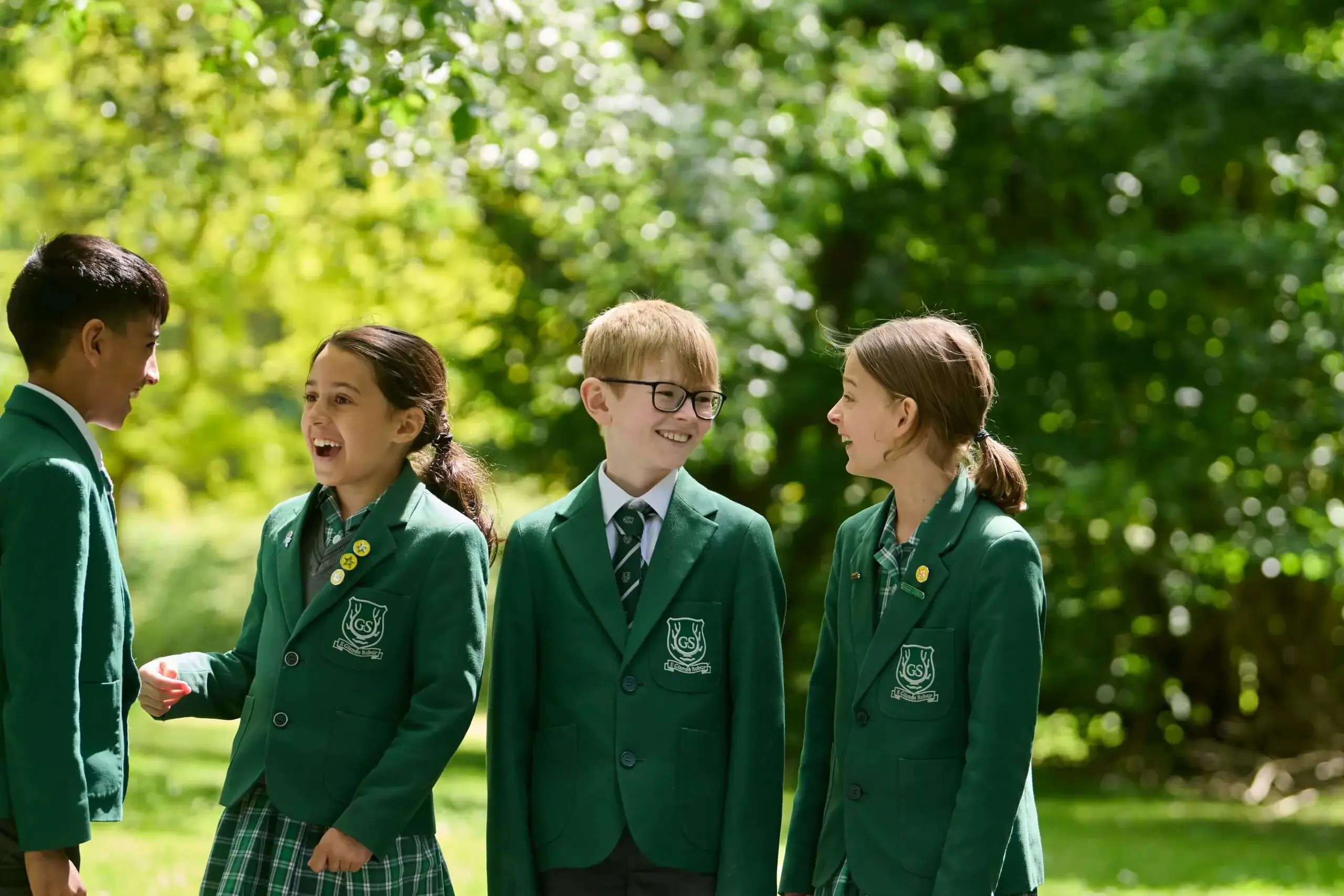 The Grange School Junior pupils chatting in the woodland.