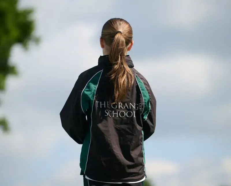 Junior pupil wearing a Grange School jacket.