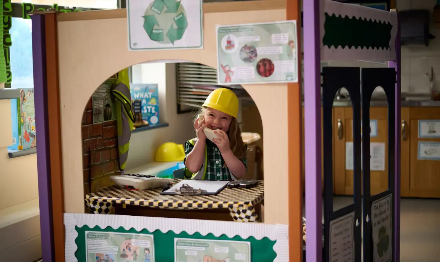 The Grange School Junior Pupil playing with a toy phone.