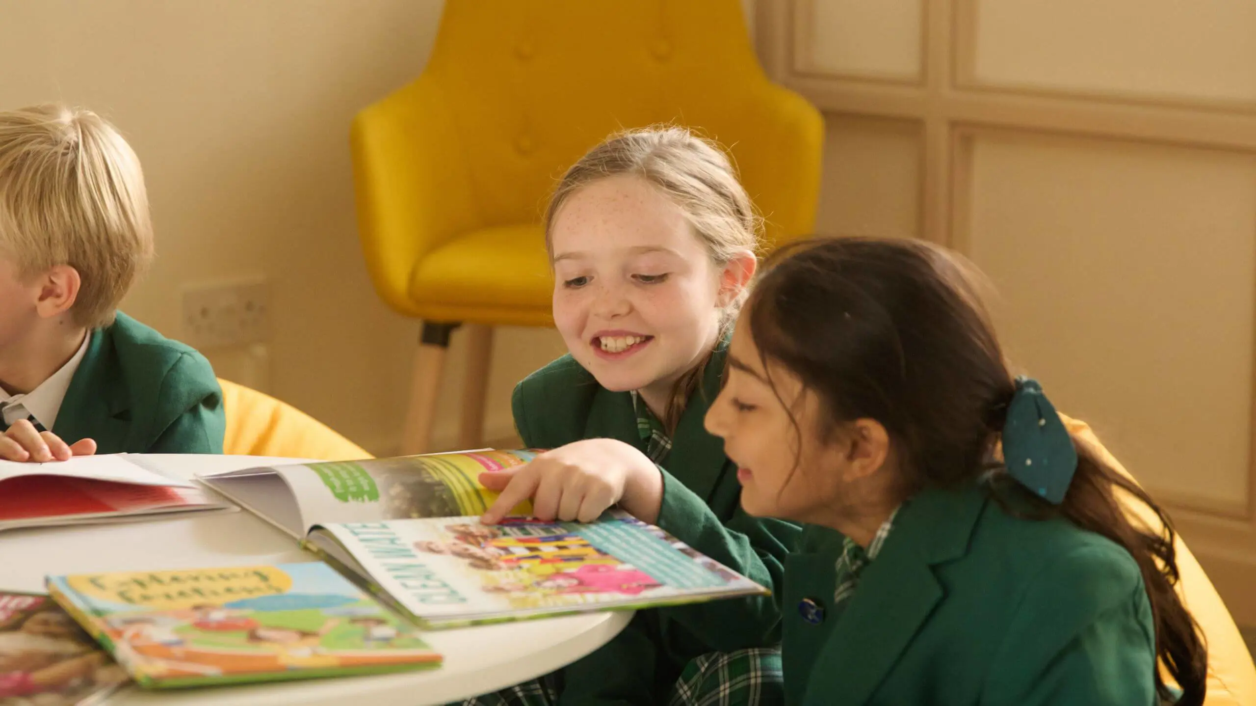 The Grange School Junior pupils reading a book together.