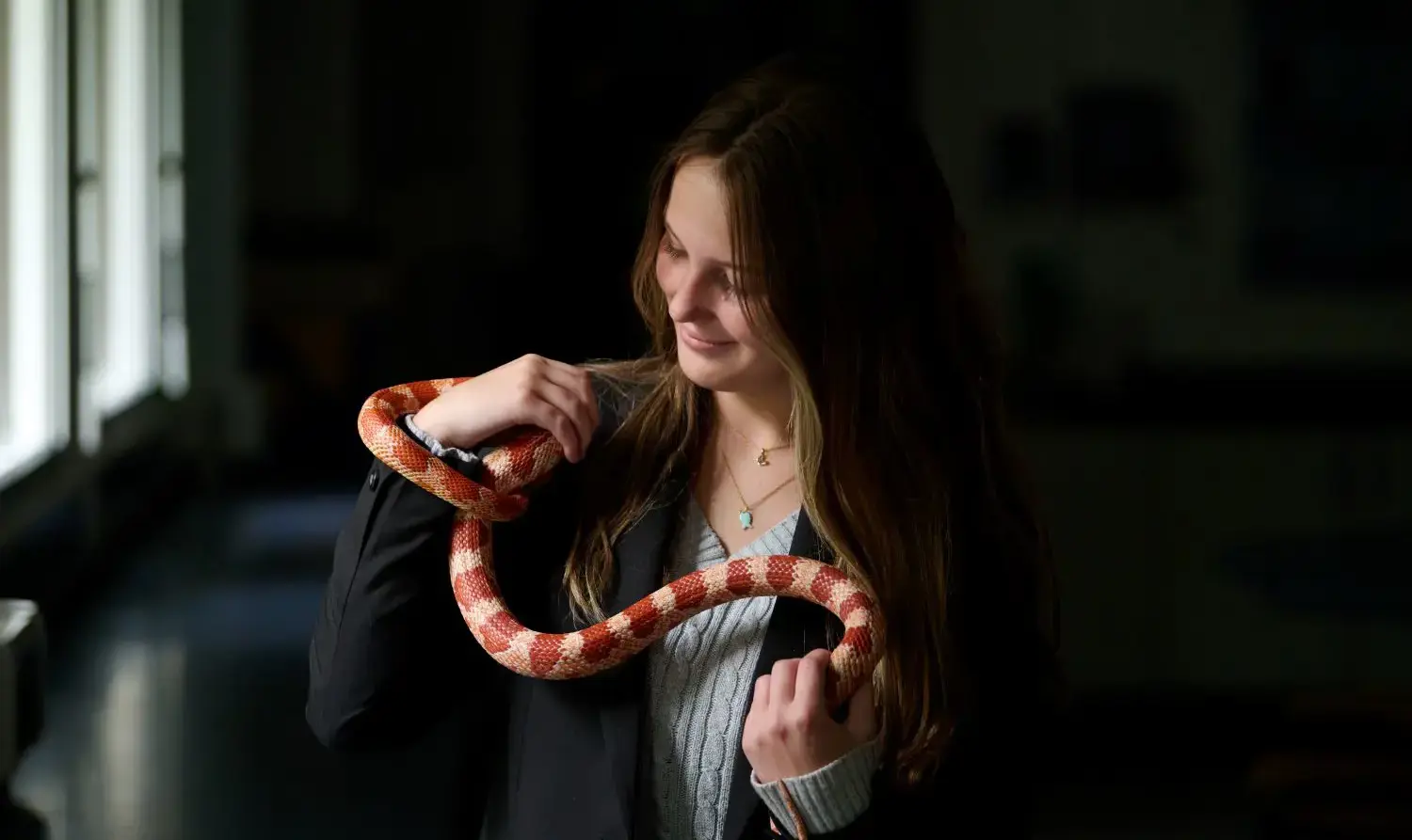 The Grange School Sixth Form Pupil holding a snake in a Biology lesson.