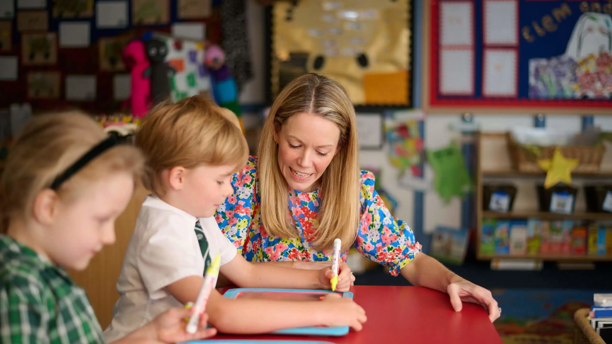 The Grange Junior School teacher helping a pupil with work in a lesson.