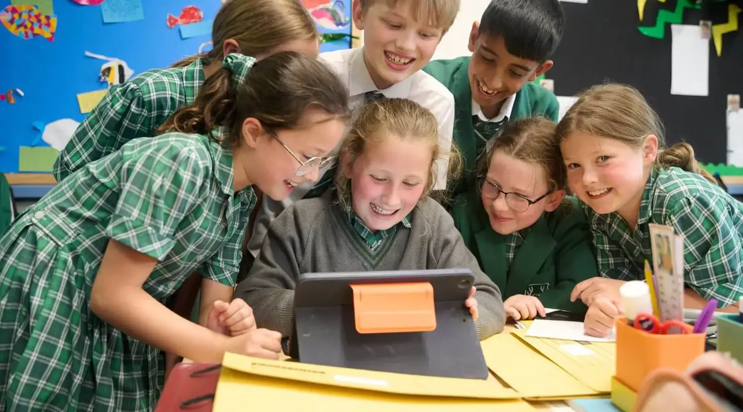 Children using an iPad in a lesson.